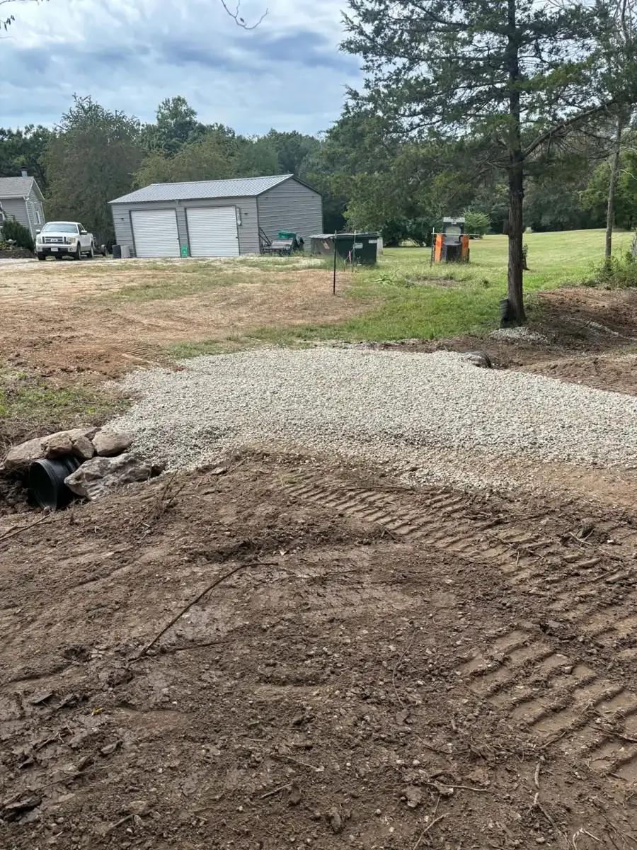 New black culvert pipe with rock armor under a gravel crossing