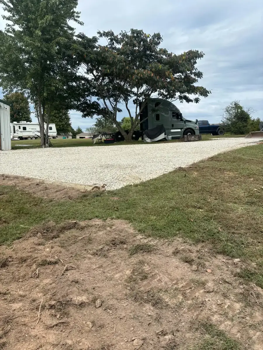 Fresh gravel driveway pad beside a lawn